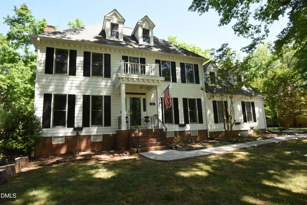 a front view of a house with yard and green space