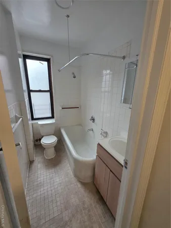 a bath room with a toilet a sink and a bath tub