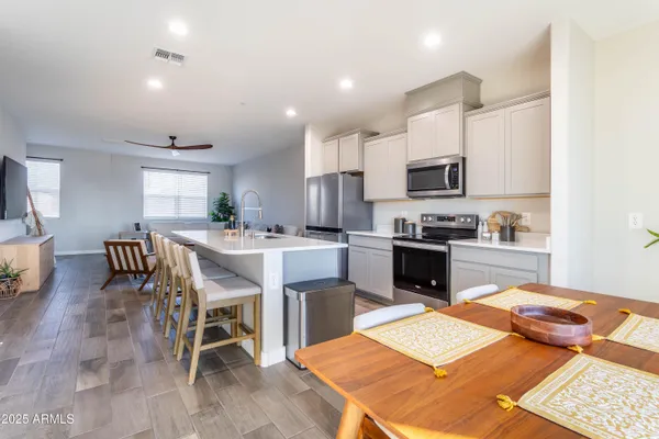 a kitchen with a table chairs a sink dishwasher refrigerator and cabinets