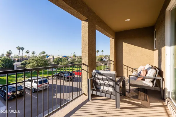 a view of a balcony with wooden floor next to a yard