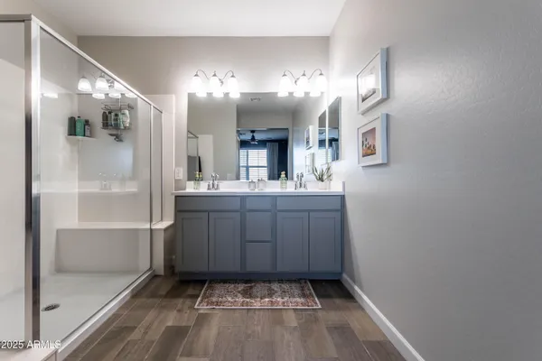 a bathroom with a sink a large mirror and a shower