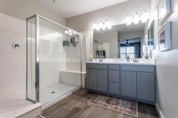 a bathroom with a double vanity sink mirror and shower