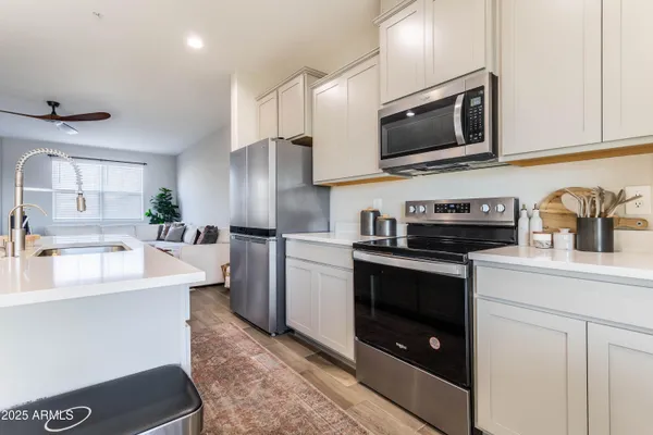 a kitchen with stainless steel appliances granite countertop a sink a stove a microwave and cabinets