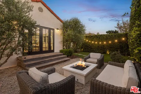 a view of a patio with couches table and chairs and potted plants