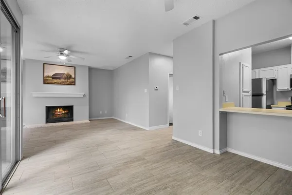 a view of an empty room with window and fireplace