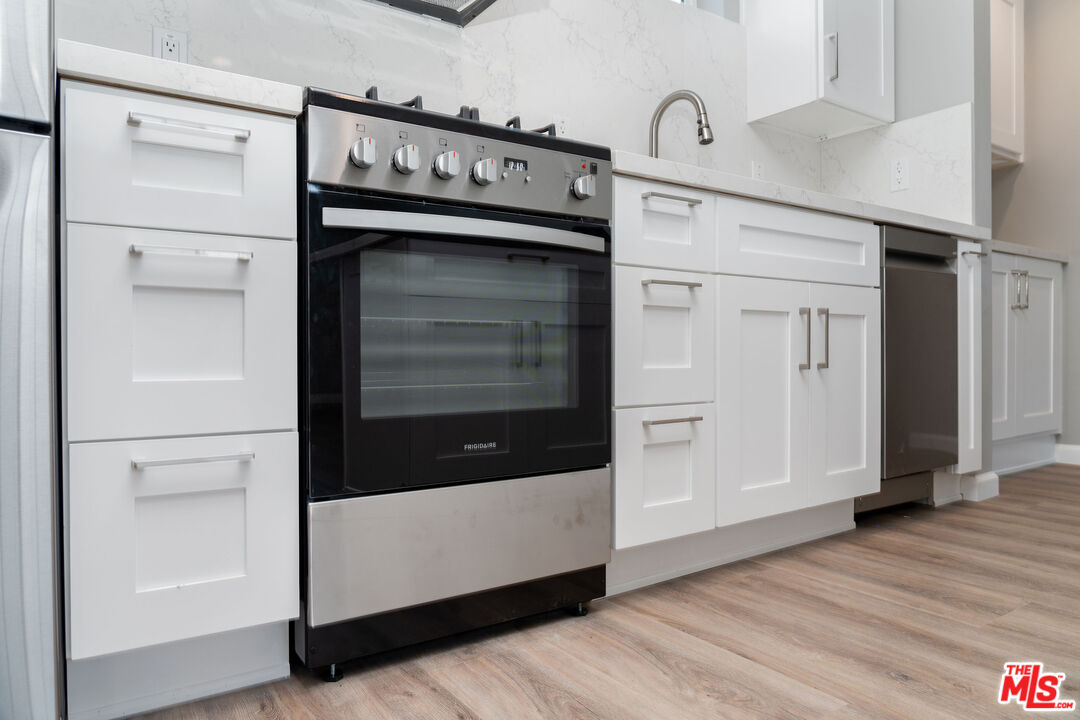 4136 McFarlane Avenue Burbank, CA 91505 - Photo 8 of 24 a kitchen with stainless steel appliances cabinets and wooden floor