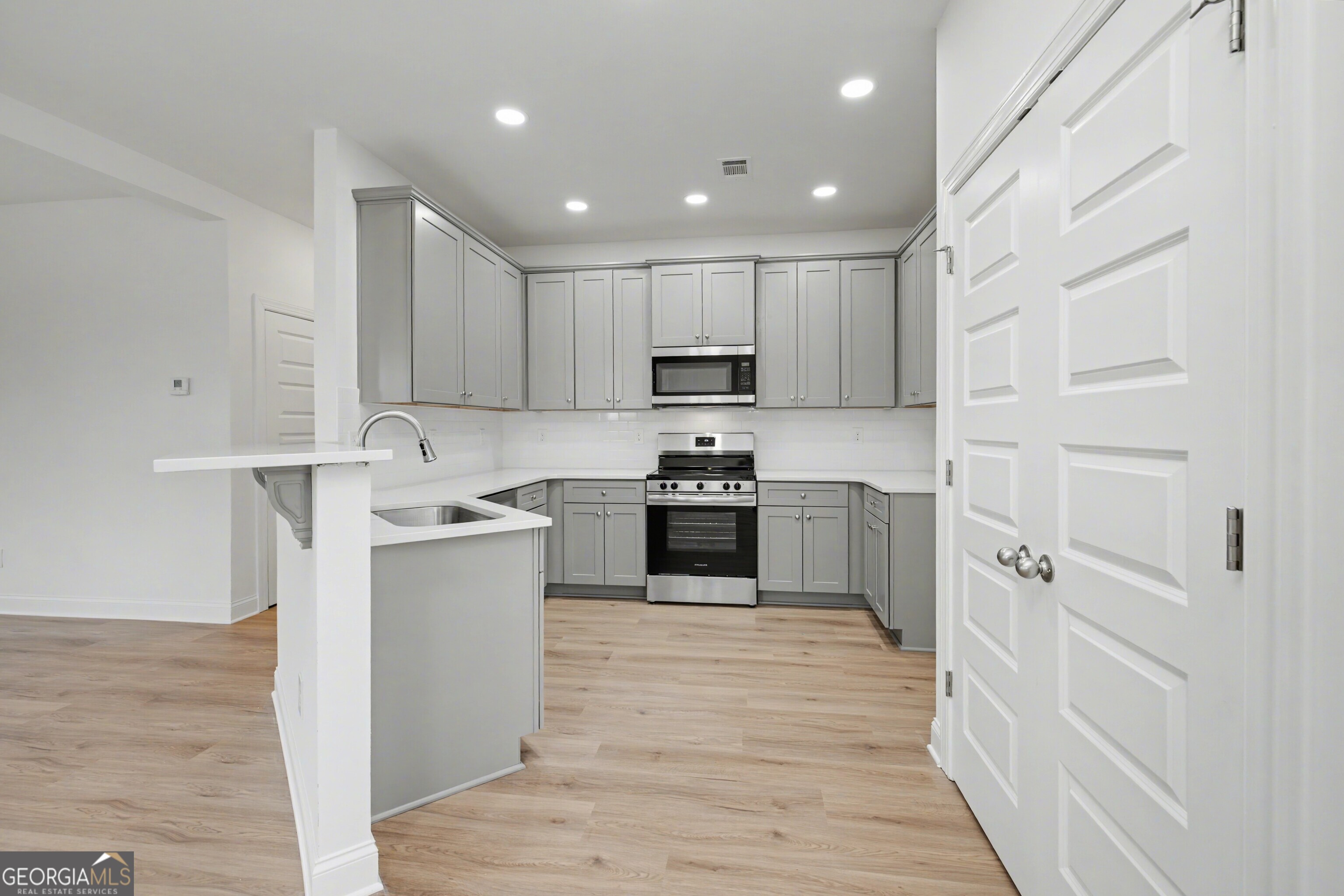 2365 New Hope Road Locust Grove, GA 30248 - Photo 15 of 44 a kitchen with stainless steel appliances white cabinets and a sink
