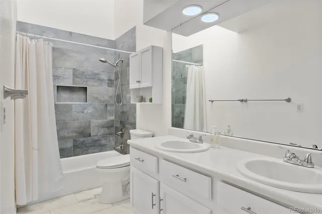 a bathroom with a granite countertop sink toilet and shower
