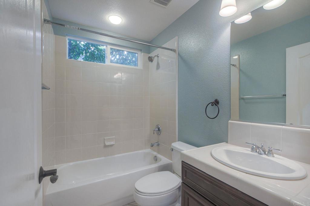 1789 Lemon Tree Court San Marcos, CA 92078 - Photo 14 of 34 a bathroom with a toilet a sink a mirror a shower and vanity