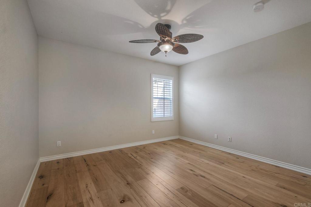1789 Lemon Tree Court San Marcos, CA 92078 - Photo 16 of 34 an empty room with wooden floor chandelier fan and windows