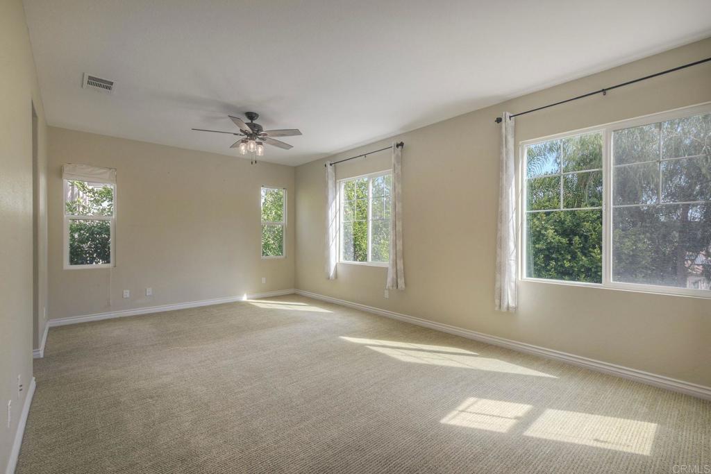 1789 Lemon Tree Court San Marcos, CA 92078 - Photo 20 of 34 an empty room with windows and chandelier fan
