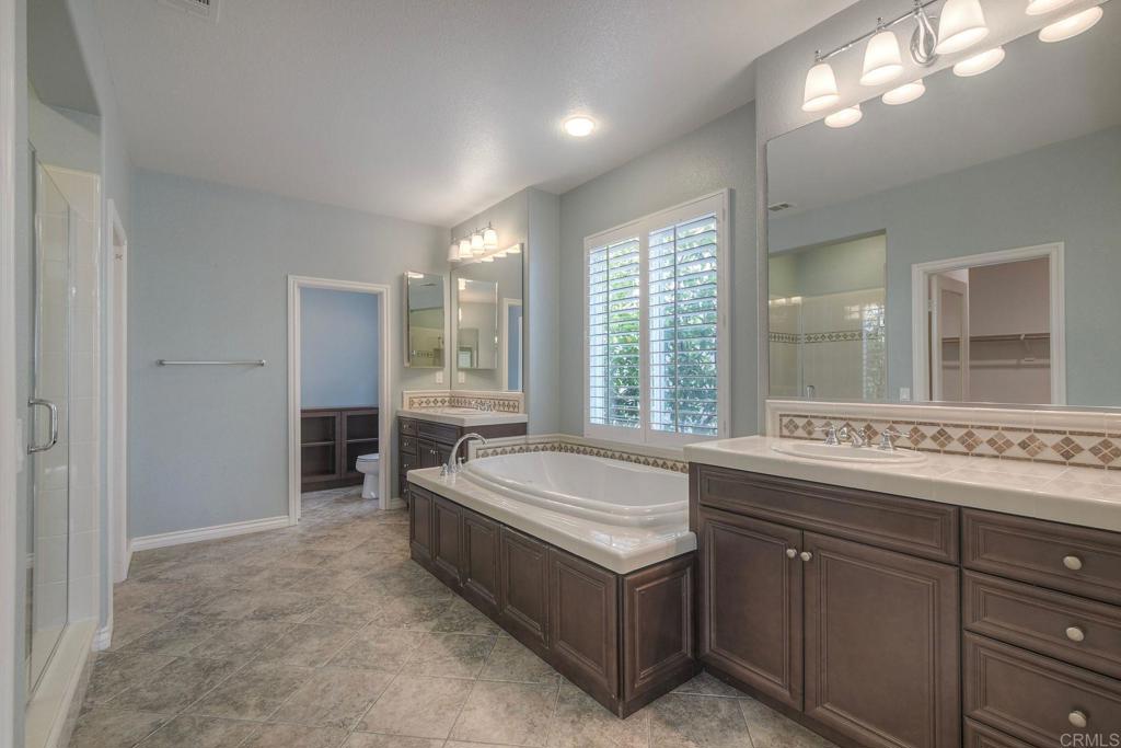 1789 Lemon Tree Court San Marcos, CA 92078 - Photo 21 of 34 a spacious bathroom with a sink and a large mirror