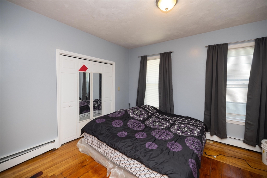 700 Franklin Street Worcester, MA 01604 - Photo 13 of 24 a bedroom with a bed and a dresser with wooden floor