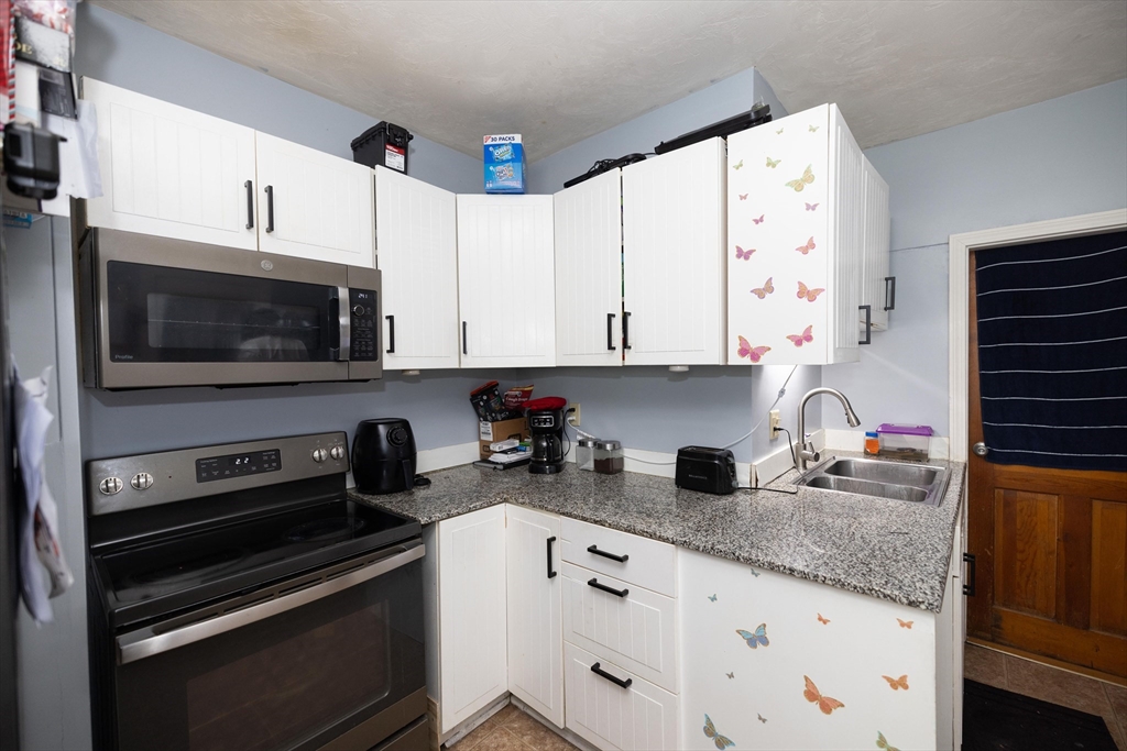 700 Franklin Street Worcester, MA 01604 - Photo 8 of 24 a kitchen with granite countertop white cabinets and stainless steel appliances
