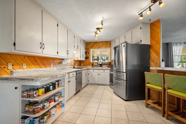 a kitchen with stainless steel appliances granite countertop a refrigerator and a stove