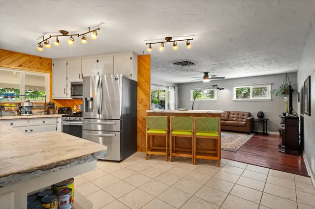a kitchen with stainless steel appliances kitchen island granite countertop a refrigerator and stove
