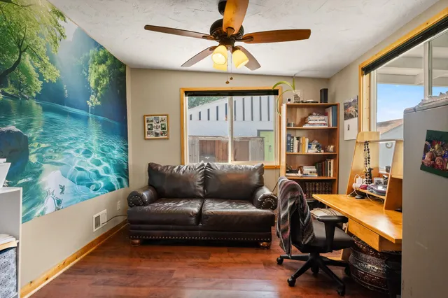 a work room with furniture and a floor to ceiling window