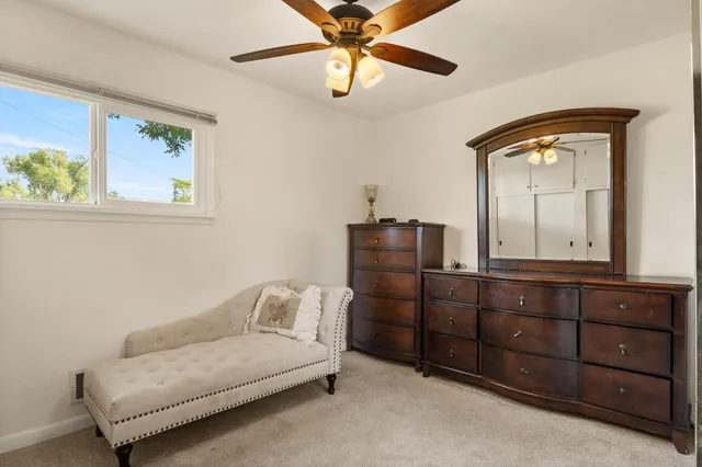 a bedroom with a bed and cabinet with mirror