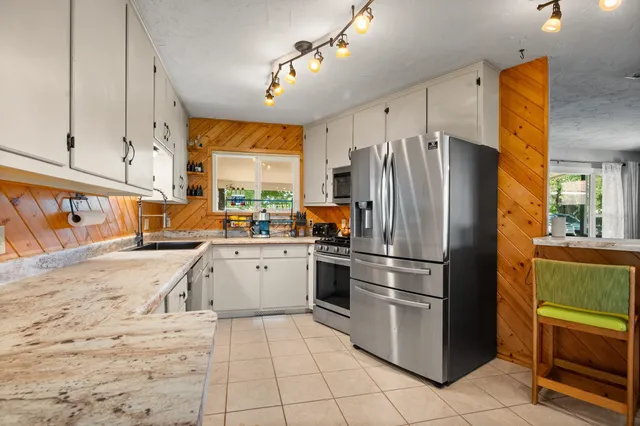 a kitchen with granite countertop a refrigerator and a sink