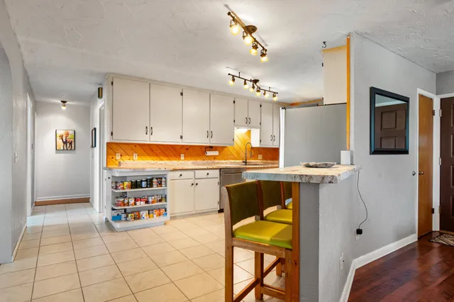 a open kitchen with stainless steel appliances granite countertop a refrigerator and a stove top oven