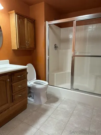 a bathroom with a toilet a sink and mirror