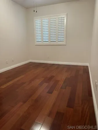 an empty room with wooden floor and closet