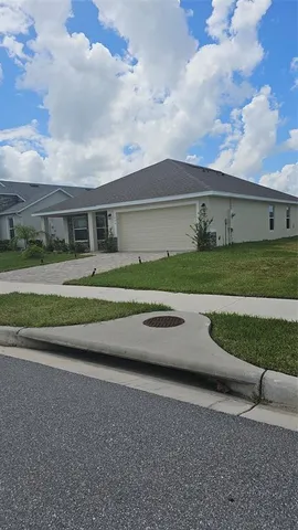 a view of a house with a yard and a large parking space