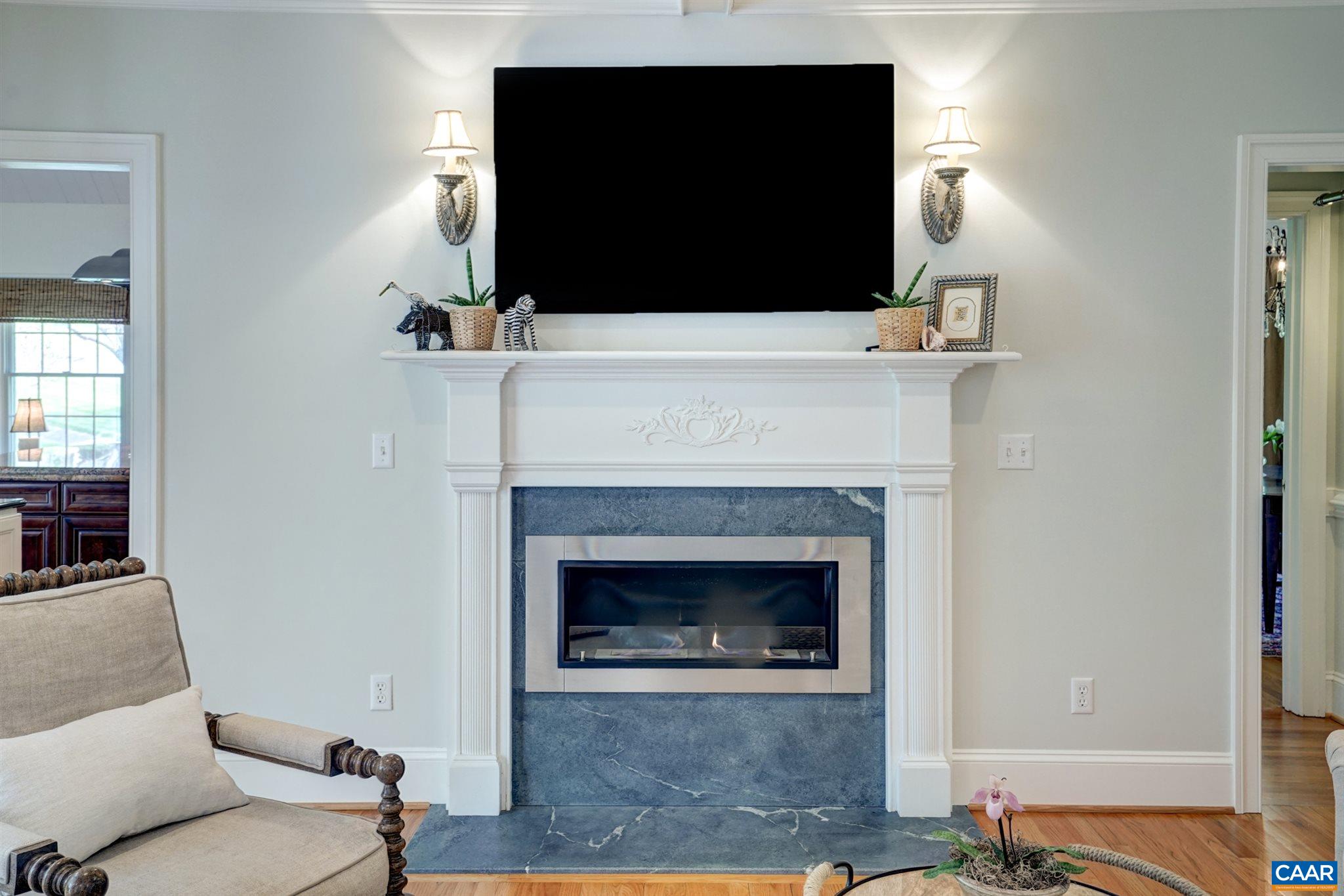 3315 Darby Road Keswick, VA 22947 - Photo 20 of 67 a living room with a fireplace and a flat screen tv