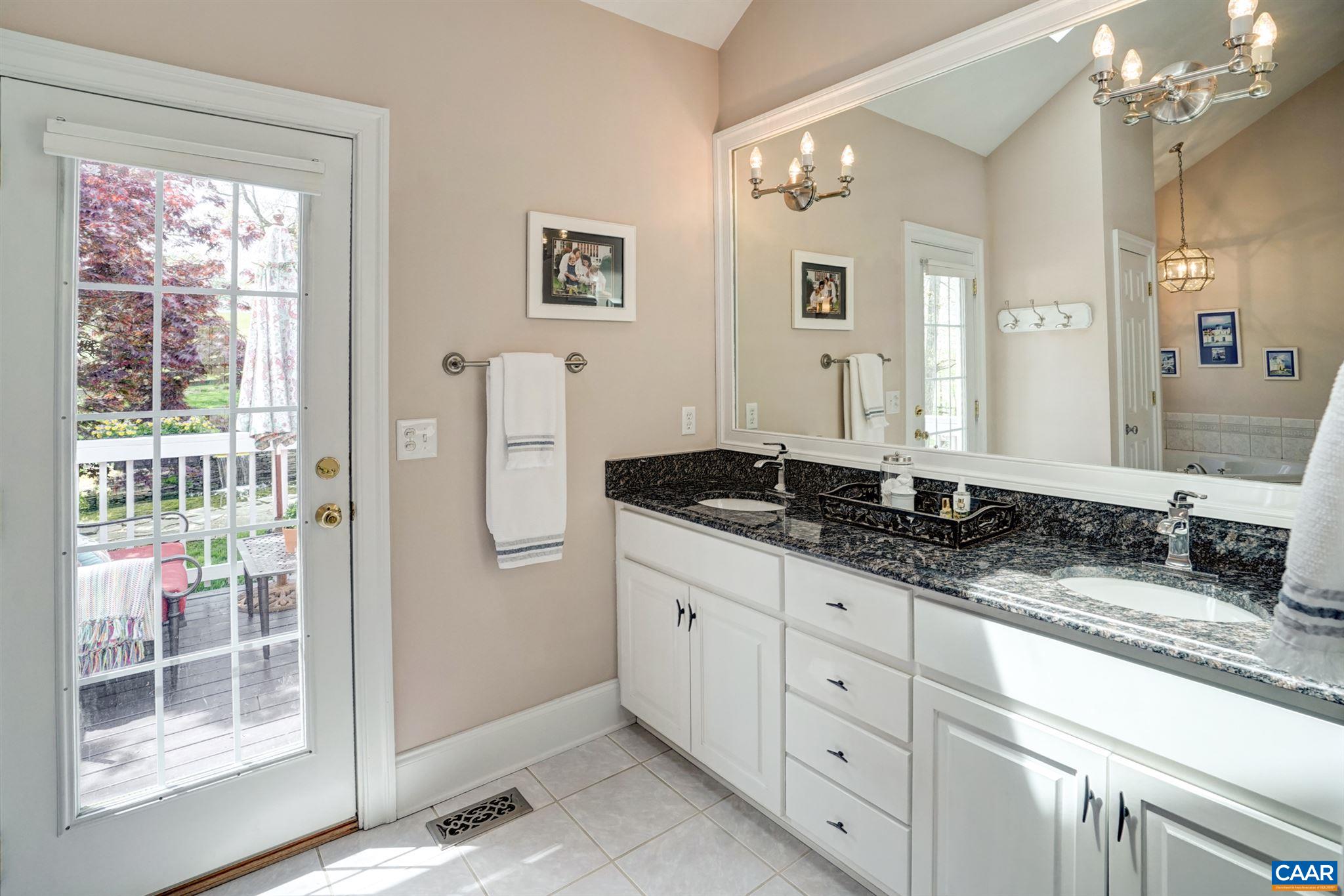 3315 Darby Road Keswick, VA 22947 - Photo 30 of 67 a bathroom with a granite countertop sink a mirror and a shower