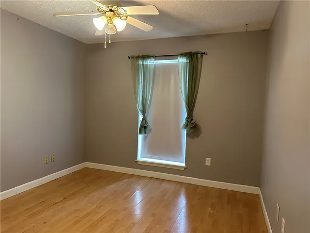 an empty room with a window and wooden floor