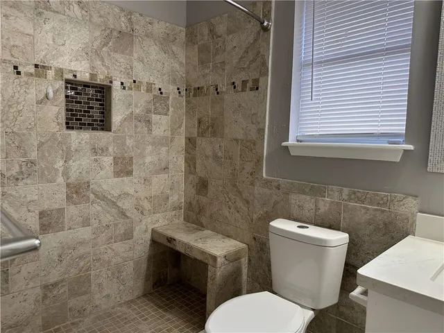 a white toilet sitting next to a bathroom sink