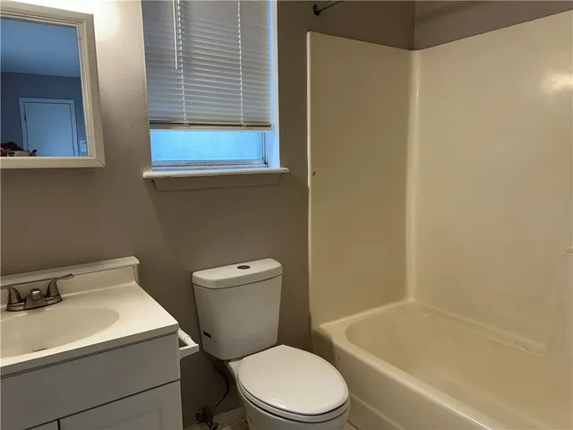 a white toilet sitting next to a bath tub