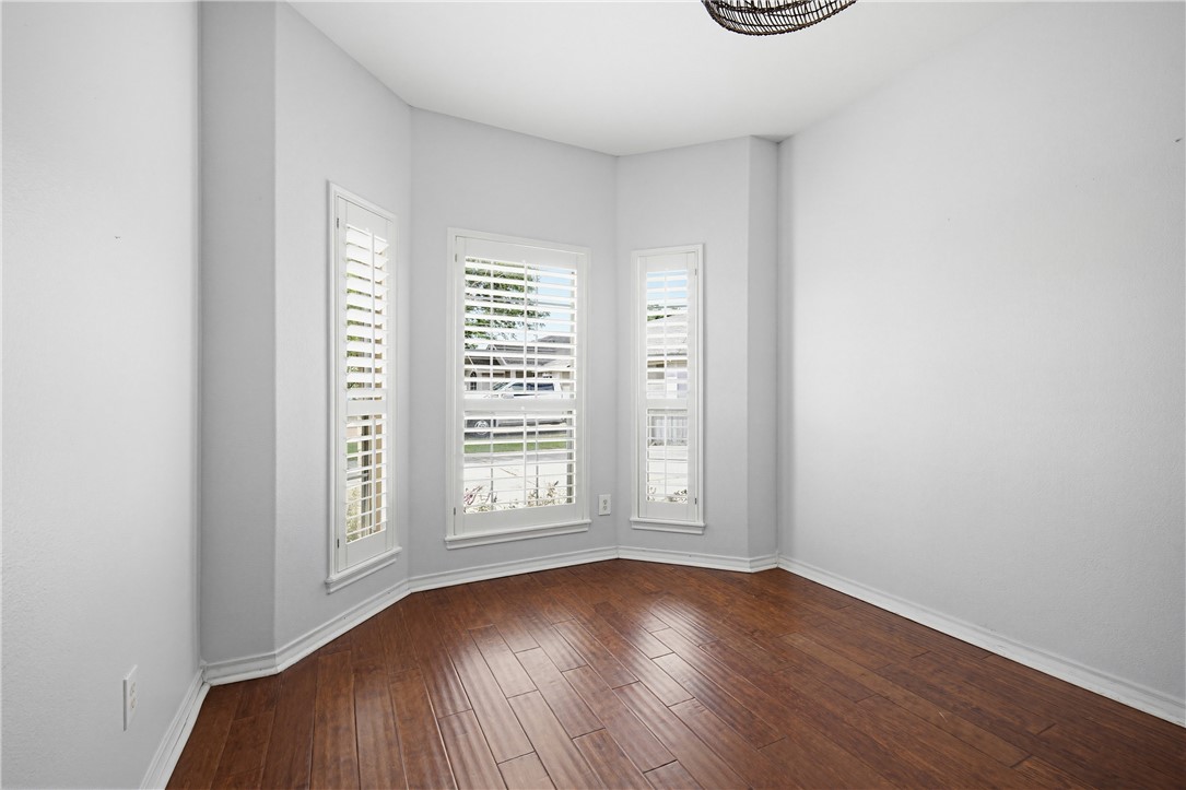 7251 Prairie Drive, Unit 6 Corpus Christi, TX 78413 - Photo 5 of 28 an empty room with wooden floor and windows