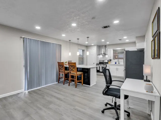 a view of a kitchen with dining room and wooden floor