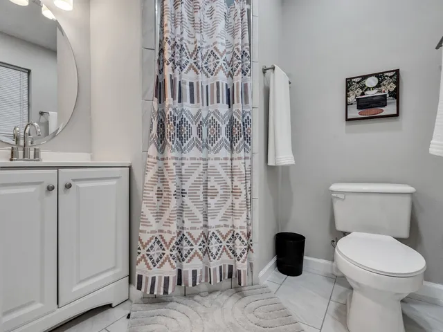 a bathroom with a toilet and a shower curtain