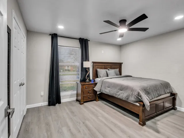 a bedroom with a large bed and a ceiling fan