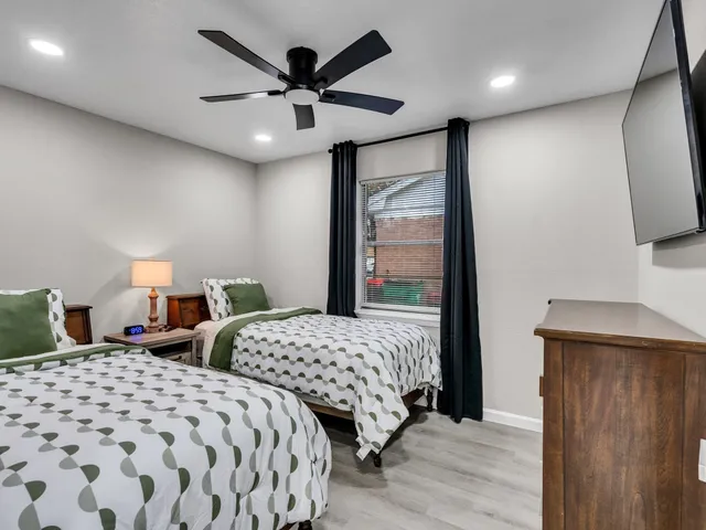 a bedroom with two beds and a large mirror