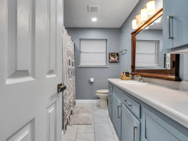 a bathroom with a sink a toilet and mirror