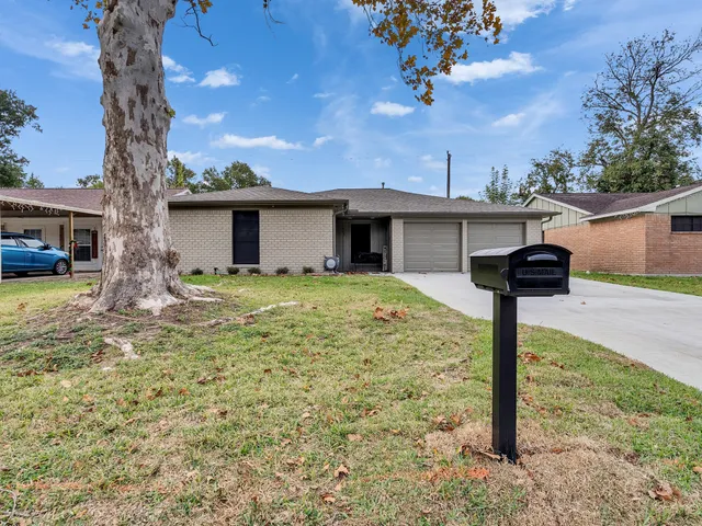 a front view of a house with yard and trees