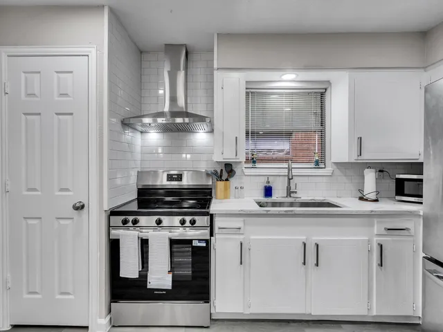 a kitchen with granite countertop white cabinets and appliances