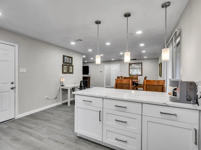 a kitchen with kitchen island a sink stainless steel appliances and wooden floor