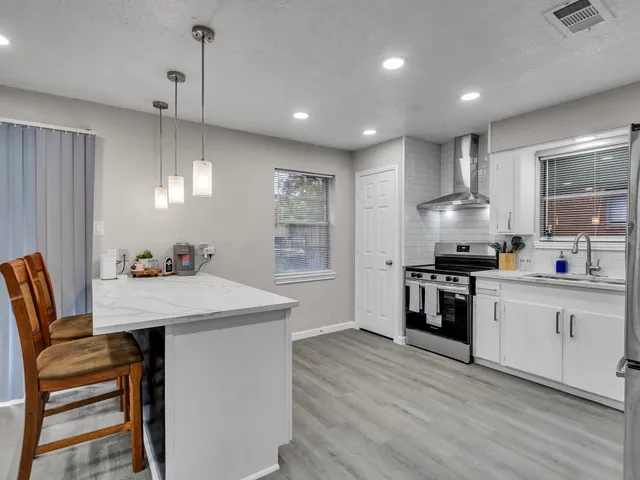 a kitchen with white cabinets stove and refrigerator
