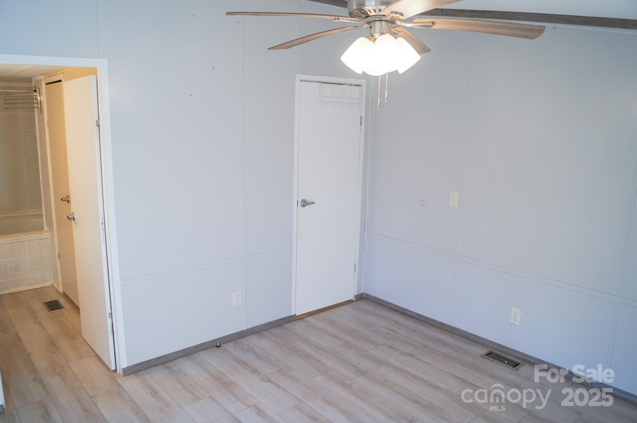 105 Lane Street Morganton, NC 28655 - Photo 14 of 19 an empty room with wooden floor and fan
