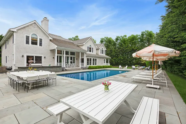 a view of swimming pool with lawn chair under an umbrella