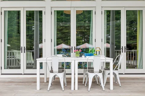 a view of a patio with couches table and chairs under an umbrella