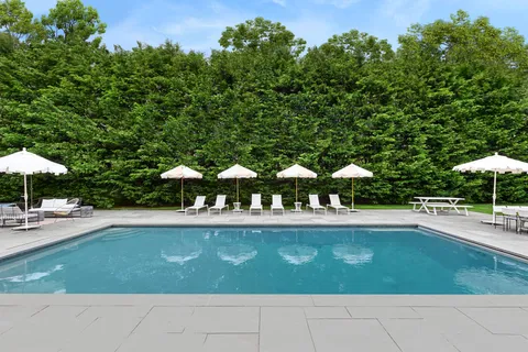 a view of a patio with table and chairs under an umbrella