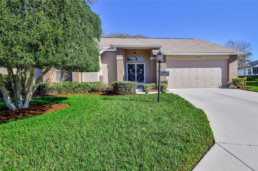 7443 Willowbrook Drive Spring Hill, FL 34606 - Photo 1 of 54 a front view of a house with a yard and garage