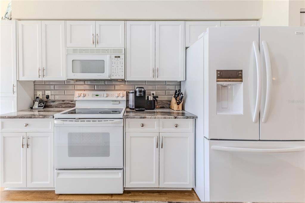 7443 Willowbrook Drive Spring Hill, FL 34606 - Photo 20 of 54 a kitchen with stainless steel appliances white cabinets and a refrigerator