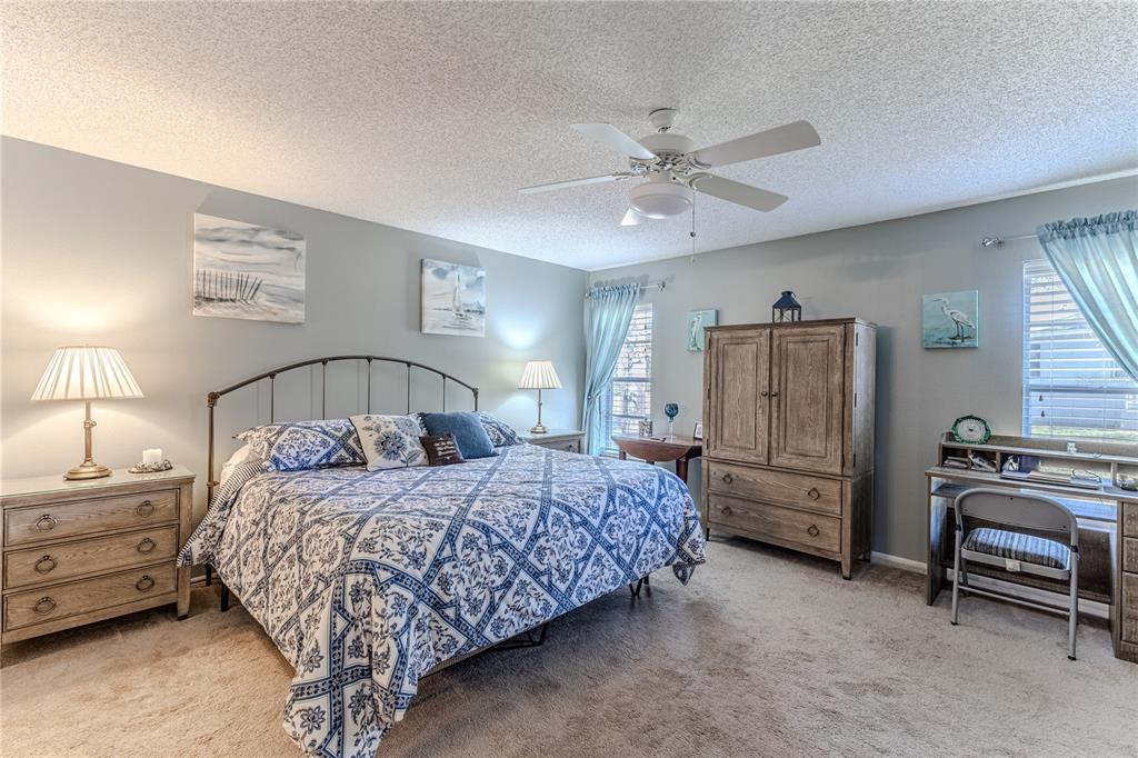 7443 Willowbrook Drive Spring Hill, FL 34606 - Photo 22 of 54 a bedroom with a bed and a chandelier