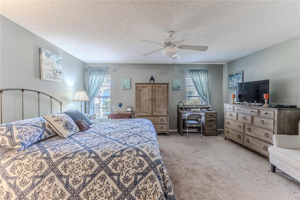 7443 Willowbrook Drive Spring Hill, FL 34606 - Photo 24 of 54 a bedroom with a large bed and a flat tv screen on dresser